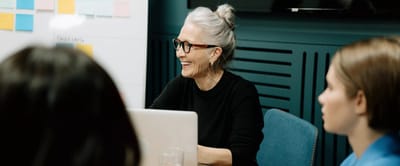 Smiling older woman participating in a meeting.