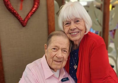 Two residents smiling together in a common area.