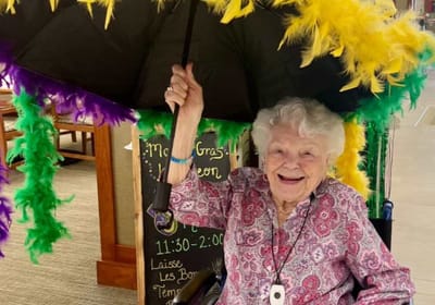 Senior woman celebrating Mardi Gras with a decorated umbrella