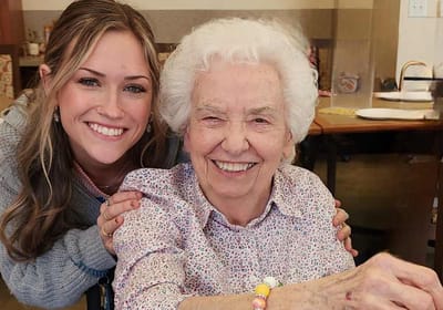 Resident and staff member smiling together