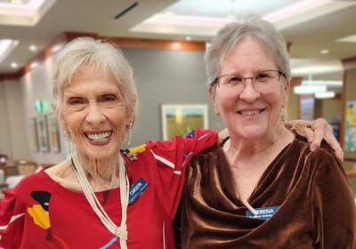 Two smiling female residents with name badges