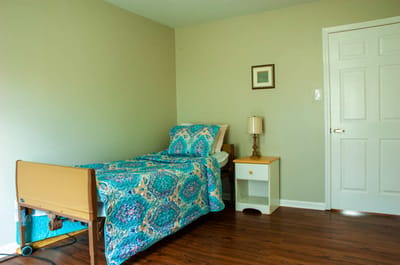 Bright private resident room with a bed and nightstand