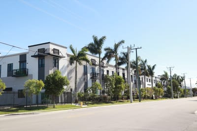 Exterior view of a contemporary senior living facility with palm trees