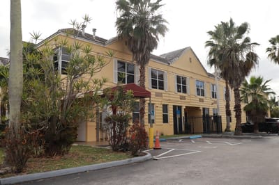 Exterior view of the facility with palm trees
