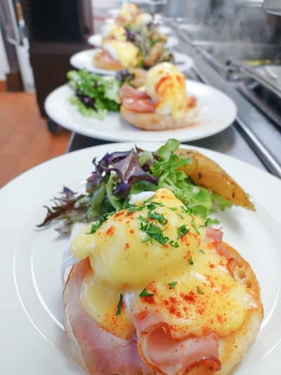 Plated eggs benedict with salad garnish