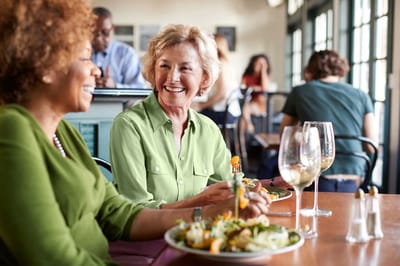 Two women enjoying a meal and conversation in a dining area