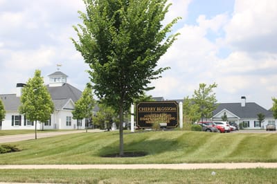 Exterior view of Cherry Blossom Senior Living facility with landscaped grounds