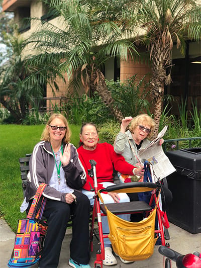 Three residents enjoying the outdoor space of the facility