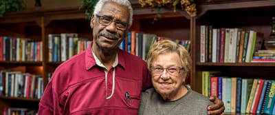 Two residents smiling in a cozy library setting