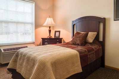 Cozy private resident room with a bed and lamp