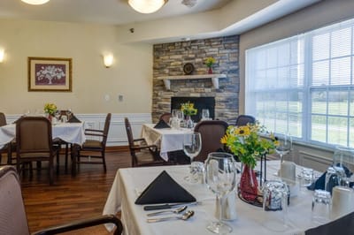 Dining area set for a meal with flowers on tables