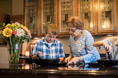 A woman and child cooking in a kitchen setting