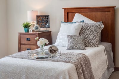 Cozy bedroom setup with decorative pillows and flowers