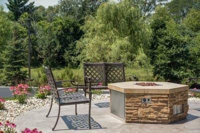 Outdoor seating area with stone fire pit and flowers