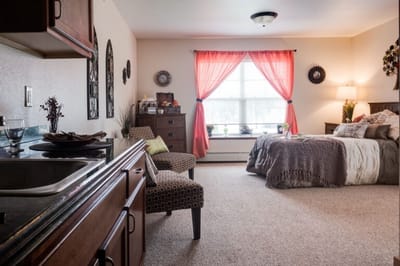 Cozy interior of a resident room with a bed and seating