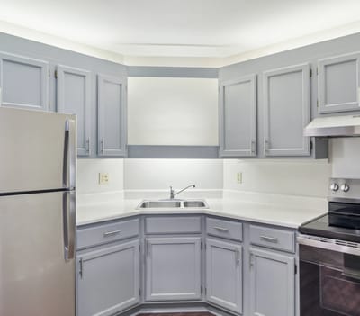 Modern kitchen area with gray cabinets and appliances