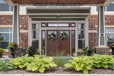 Front entrance of a senior living facility with plants