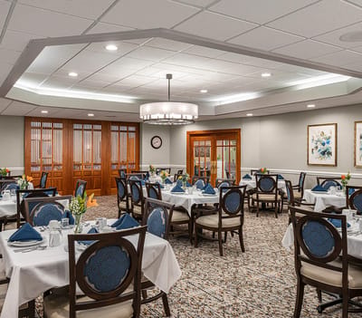 Dining room set up for a meal with tables and chairs