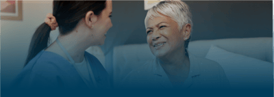 A caregiver smiling with a resident in a cozy room