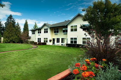 Exterior view of the assisted living facility with gardens