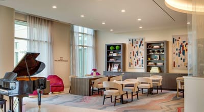 Bright common area with seating and a piano