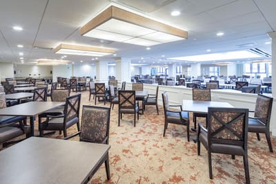 Dining room with tables and chairs set for residents