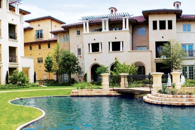 Exterior view of the facility with a pool and landscaping
