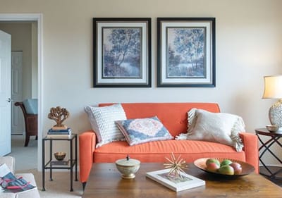 Cozy living room with orange couch and artwork