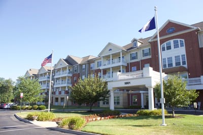 Exterior view of a senior living facility with flags
