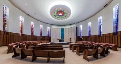 Interior view of a serene chapel with wooden benches