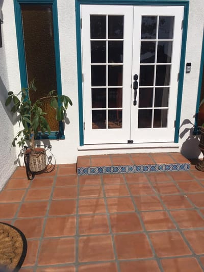 Outdoor patio area with double doors and tile steps