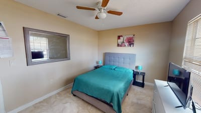 A well-decorated private resident room with a bed and TV.