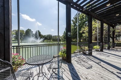 Outdoor seating area overlooking a pond with fountain