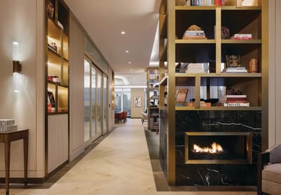 Stylish interior common area with bookshelves and fireplace