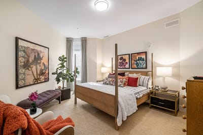 A cozy resident room with a bed and decorative art