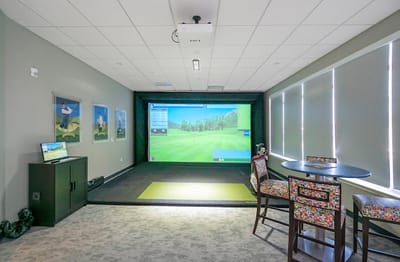 Indoor golf simulator area with seating