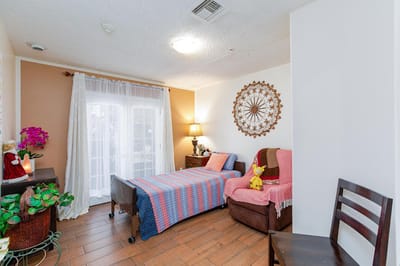 Cozy interior of a resident room with a bed and chair