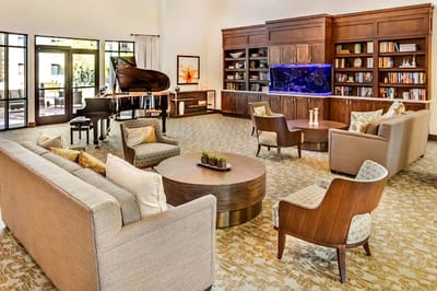 Common area with seating and piano in a senior living facility