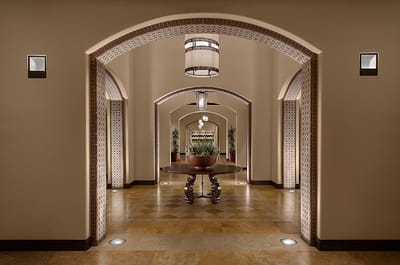Interior hallway with decorative arches and plants