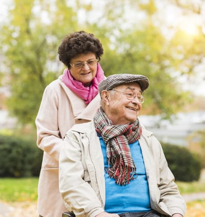 Senior couple enjoying outdoors with warmth and smiles.
