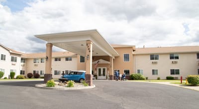 Exterior view of the facility entrance with residents and staff