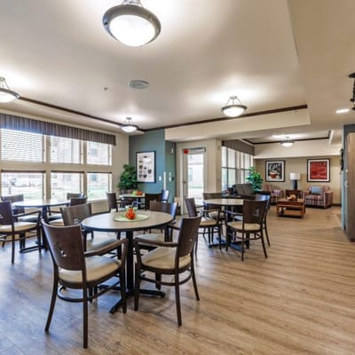 Common area with tables and chairs in a senior living facility