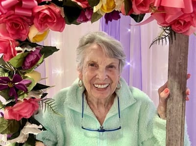 Smiling resident posing with floral decoration