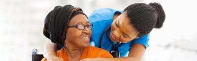 A caregiver smiling with a resident indoors