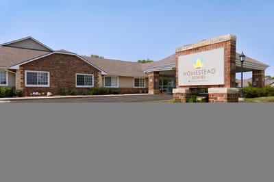 Facility building exterior with sign and landscaped area