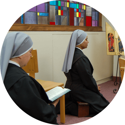 Nuns praying in a serene interior space