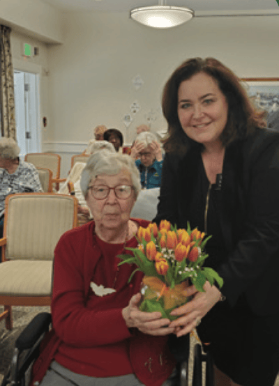 Resident receiving a bouquet of flowers during an event