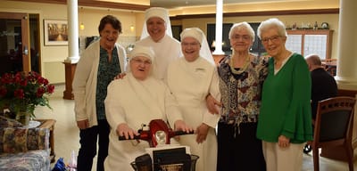 Group photo of staff and residents in a common area
