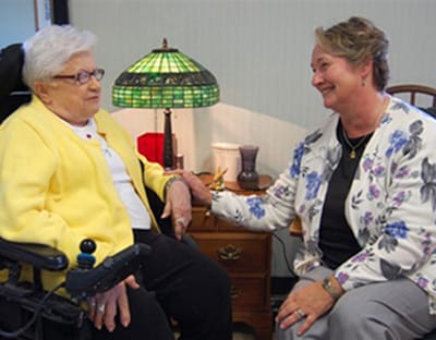 A caregiver interacting with a resident in a cozy interior setting