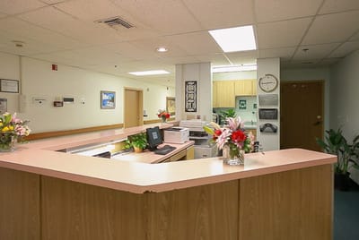 Reception area with flowers and a computer station